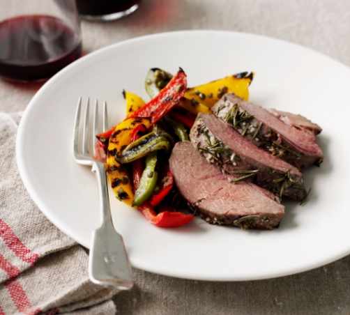 A plate of delicious roasted peppers and medium rare roast beef slices.