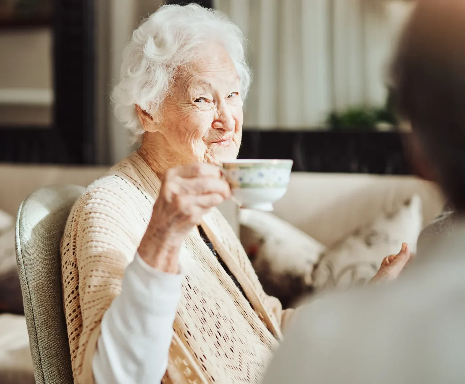 Smug elderly lady with cup of tea