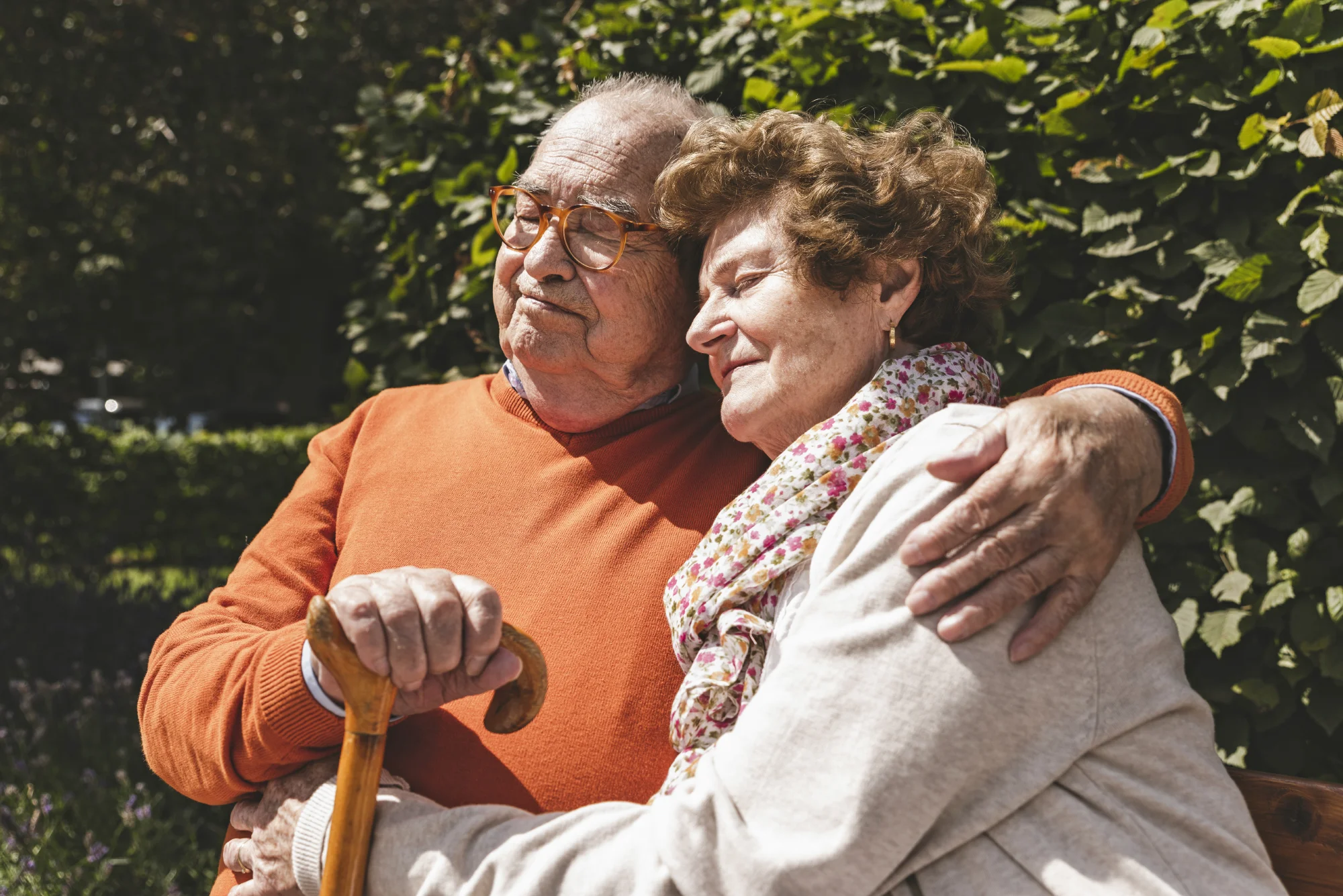 Senior couple embracing on park bench